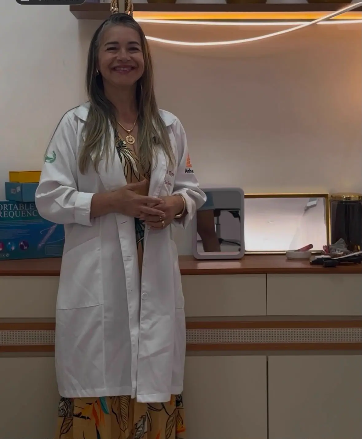 Enfermeira responsável da Clínica INJECTOR, de jaleco branco, no consultório